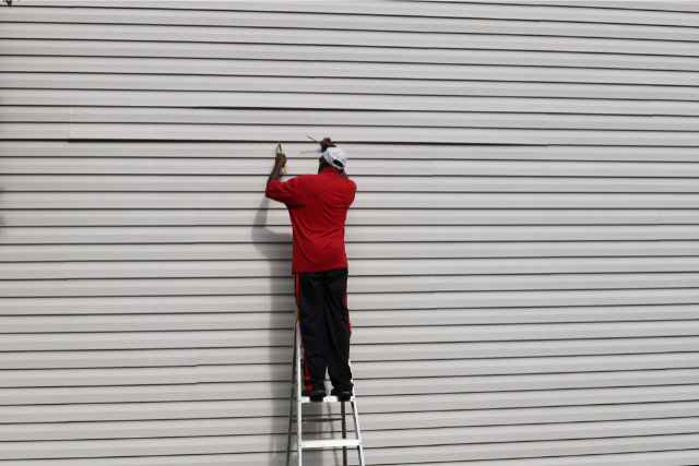Siding Repair by a worker on a ladder